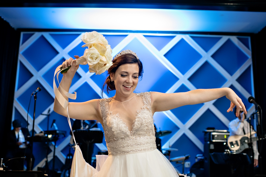 A bride dancing with her bouquet.